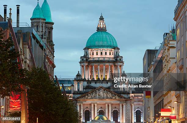 facade and dome of belfast city hall at dusk - belfast stock pictures, royalty-free photos & images