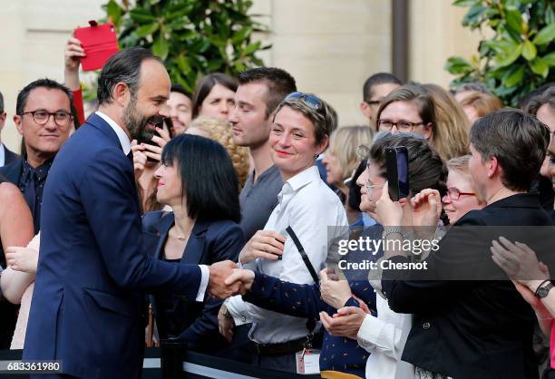 France's newly-appointed Prime Minister Edouard Philippe shake hands with employees after an official handover ceremony with outgoing Prime Minister...