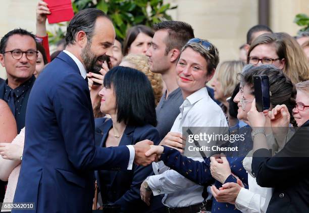 France's newly-appointed Prime Minister Edouard Philippe shake hands with employees after an official handover ceremony with outgoing Prime Minister...