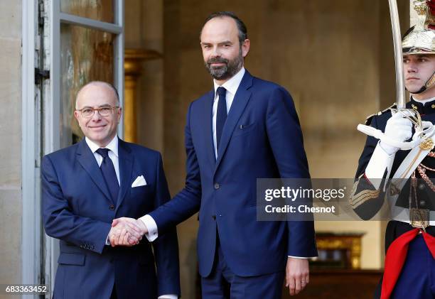 France's newly-appointed Prime Minister Edouard Philippe and outgoing Prime Minister Bernard Cazeneuve shake hands during the official handover...