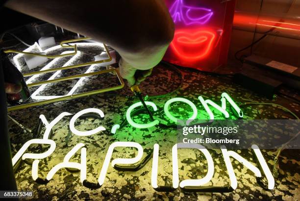 An illuminated neon sign sits on a table during production at Precision Neon in the Brooklyn borough of New York, U.S., on Thursday, May 11, 2017....