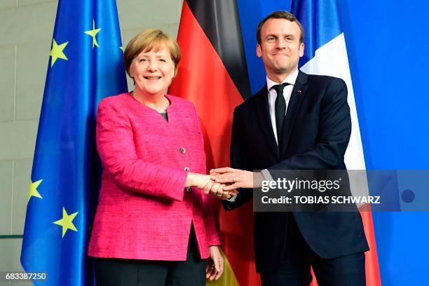 German Chancellor Angela Merkel and French President Emmanuel Macron shake hands after addressing a press conference after talks at the chancellery...