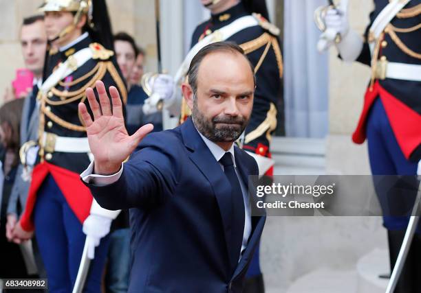 France's newly-appointed Prime Minister Edouard Philippe waves after an official handover ceremony with outgoing Prime Minister Bernard Cazeneuve at...