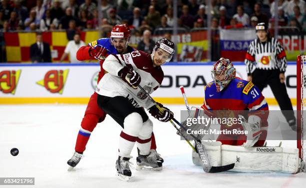 Viktor Antipin of Russia challenges Teodors Blugers of Latvia for the puck during the 2017 IIHF Ice Hockey World Championship game between Russia and...