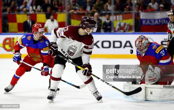 Viktor Antipin of Russia challenges Teodors Blugers of Latvia for the puck during the 2017 IIHF Ice Hockey World Championship game between Russia and...