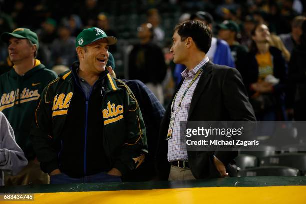 Managing Partner John Fisher and President David Kaval of the Oakland Athletics talk in the stands during the game against the Seattle Mariners at...