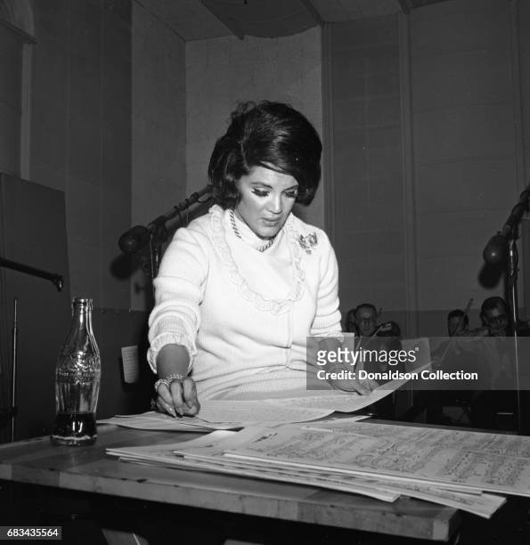 Entertainer Connie Francis recording with a bottle of Coca Cola on May 31, 1966 in New York.
