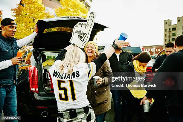woman with foam finger dancing with friend - tailgating stock pictures, royalty-free photos & images
