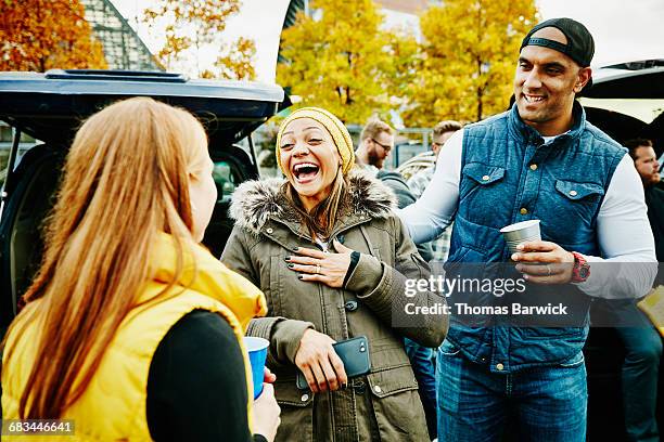 laughing friends hanging out at tailgating party - adulation stock pictures, royalty-free photos & images