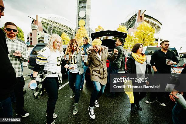 group of women dancing at tailgating party - fan appreciation day stock-fotos und bilder