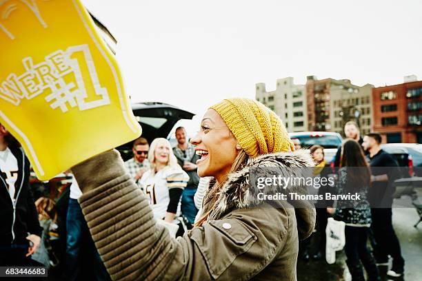 woman with foam finger celebrating with friends - fan appreciation day stock-fotos und bilder