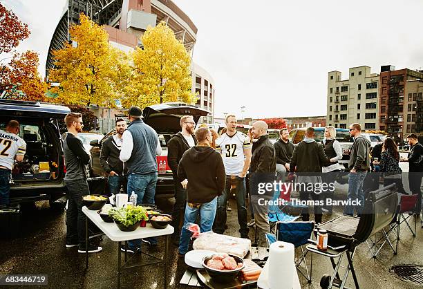 friends tailgating in stadium parking lot - tailgating stock pictures, royalty-free photos & images