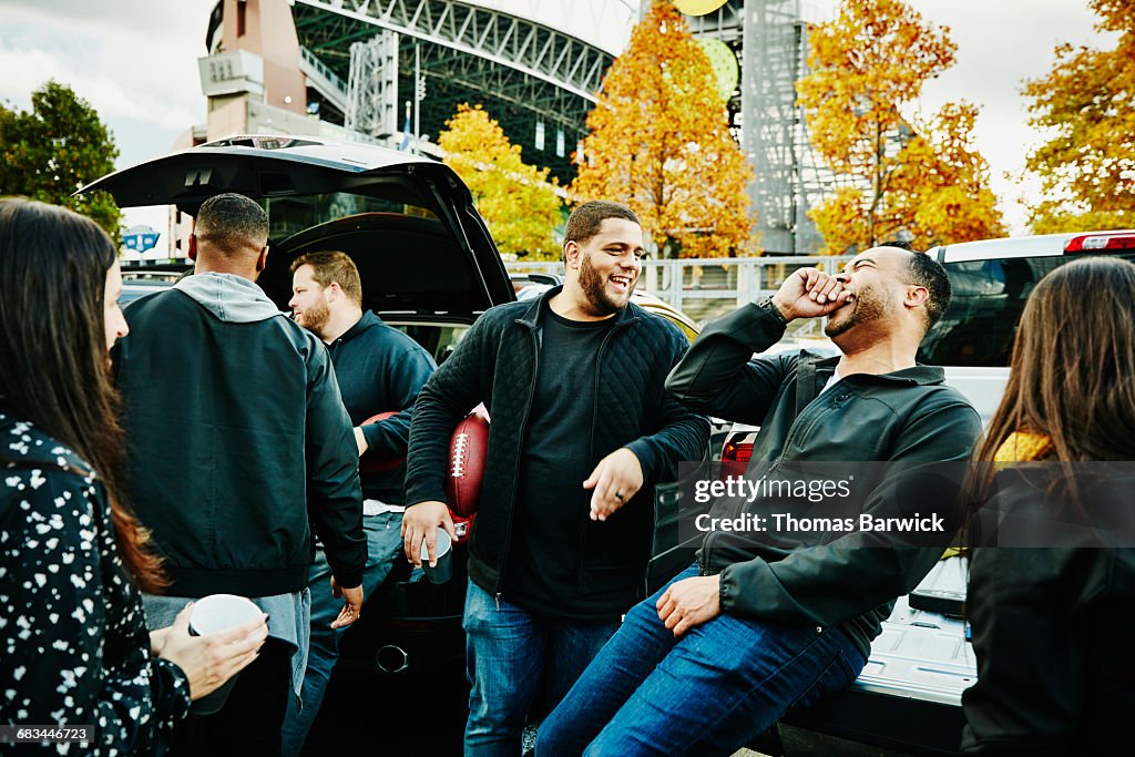 Friends laughing together during tailgating party
