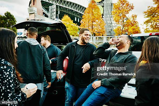 friends laughing together during tailgating party - man admiring car stock pictures, royalty-free photos & images
