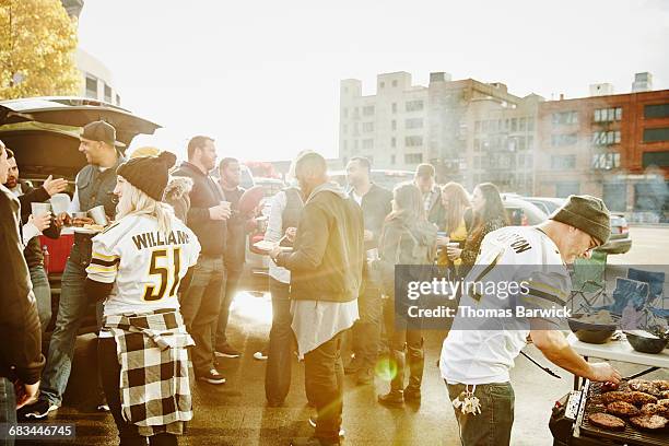 friends tailgating in stadium parking lot - straatfeest stockfoto's en -beelden