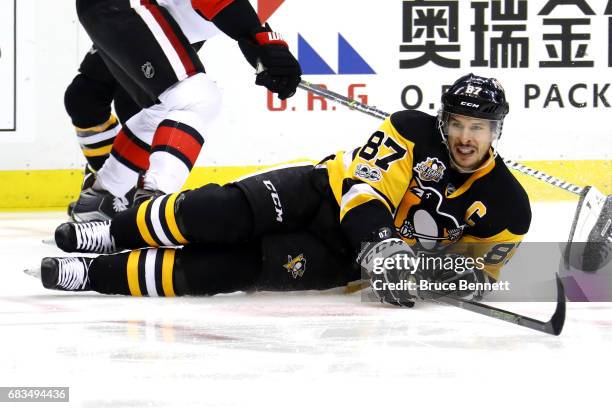 Sidney Crosby of the Pittsburgh Penguins lays on the ice after being tripped by Erik Karlsson of the Ottawa Senators during the second period in Game...