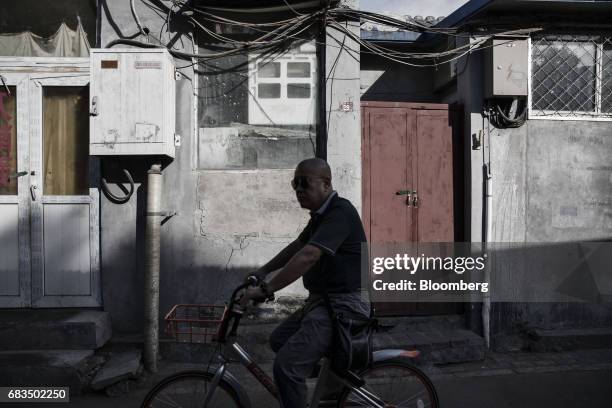 Cyclist passes through a traditional hutong neighborhood in Beijing, China, on Sunday, May 14, 2017. Chinas economy is staging a comeback as...