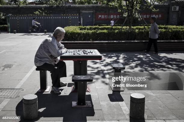 Man plays Chinese chess while sitting in a park in a traditional hutong neighborhood in Beijing, China, on Sunday, May 14, 2017. Chinas economy is...
