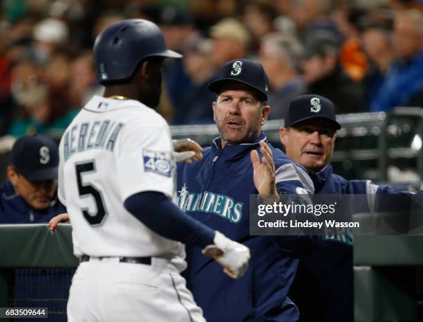 Seattle Mariners left fielder Guillermo Heredia is greeted by batting coach and former Mariner Edgar Martinez after scoring on a bases loaded walk in...