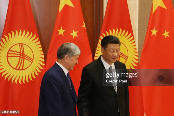 Kyrgyzstan President Almazbek Sharshenovich Atambayev and Chinese President Xi Jinping walk ahead a bilateral meeting at Diaoyutai State Guesthouse...