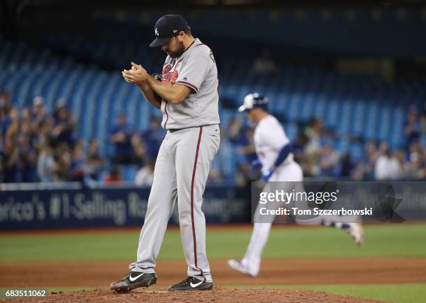 Josh Collmenter of the Atlanta Braves reacts after giving up a two-run home run in the ninth inning during MLB game action to Justin Smoak of the...