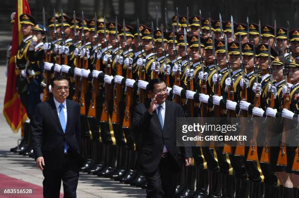 Cambodia's Prime Minister Hun Sen reviews a military honour guard with Chinese Premier Li Keqiang during a welcome ceremony outside the Great Hall of...