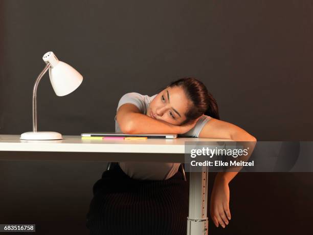 woman at desk resting on desk and staring into space - perder el tiempo fotografías e imágenes de stock