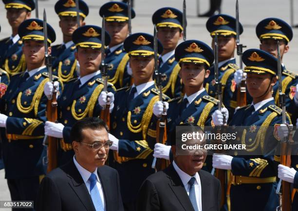 Cambodia's Prime Minister Hun Sen reviews a military honour guard with Chinese Premier Li Keqiang during a welcome ceremony outside the Great Hall of...