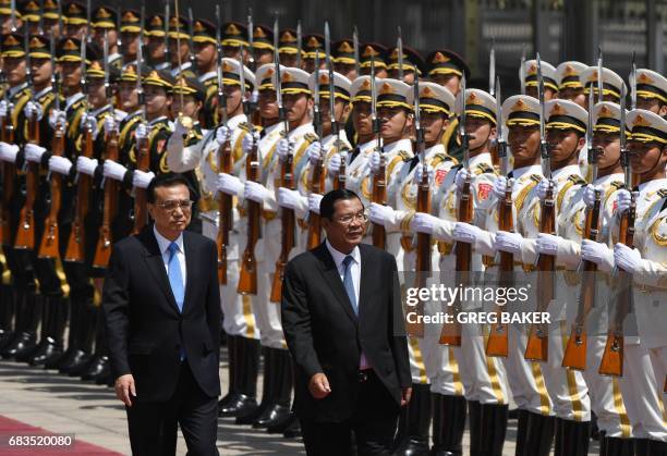 Cambodia's Prime Minister Hun Sen reviews a military honour guard with Chinese Premier Li Keqiang during a welcome ceremony outside the Great Hall of...