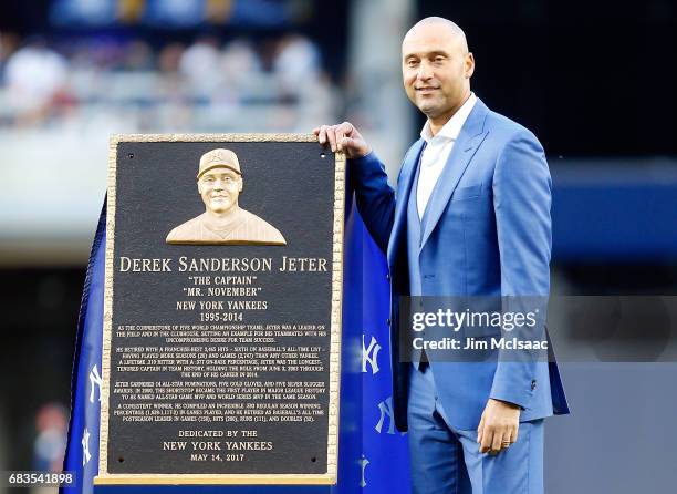 Derek Jeter poses with his Monument park plaque during his number retirement ceremony at Yankee Stadium on May 14, 2017 in the Bronx borough of New...