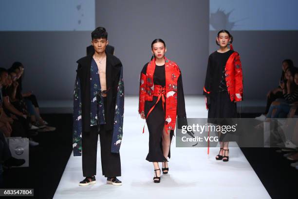 Models showcase designs designed by graduates of College of Fine Arts of University of Jinan on the runway during day one of China Graduate Fashion...