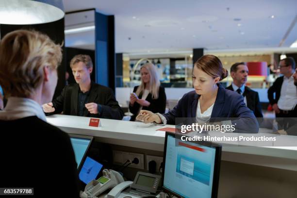 businesswoman checking into hotel at reception - reception 2017 ストックフォトと画像