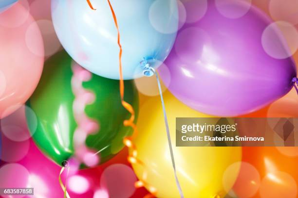 close-up of many bright colorful funny balloons under ceiling, as background - decorative balloons ストックフォトと画像