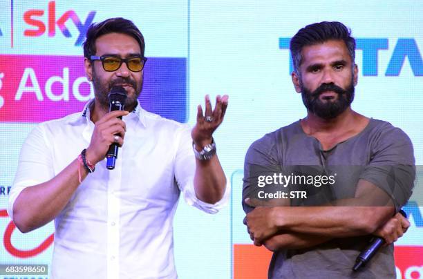 Indian Bollywood actors Ajay Devgn and Suniel Shetty talk onstage during the launch of 'Acting Adda' in Mumbai on 16 May, 2017. / AFP PHOTO / STR