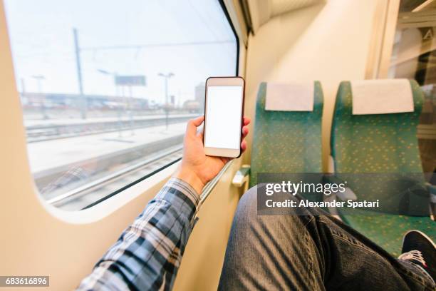 man using smartphone on a high speed train - smartphone im zug stock-fotos und bilder