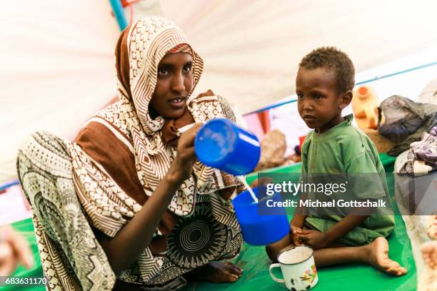 Waaf Dhuung, Ethiopia A mother prepares milk from milk powder for her son. Unicef feeding in a village in the Somali region of Ethiopia, where...