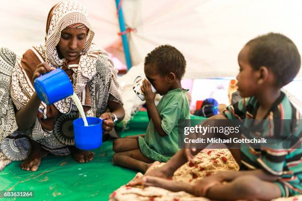 Waaf Dhuung, Ethiopia A mother prepares milk from milk powder for her children. Unicef feeding in a village in the Somali region of Ethiopia, where...