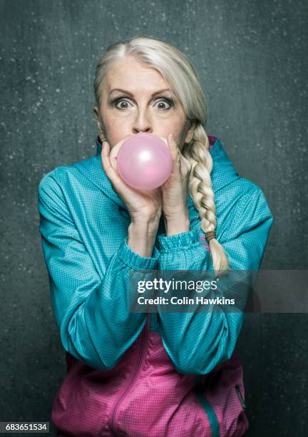 senior woman blowing up balloon - bristol balloon stock pictures, royalty-free photos & images