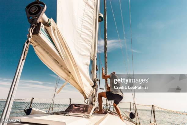 uomo che naviga e pesca durante le vacanze estive - barca a vela foto e immagini stock