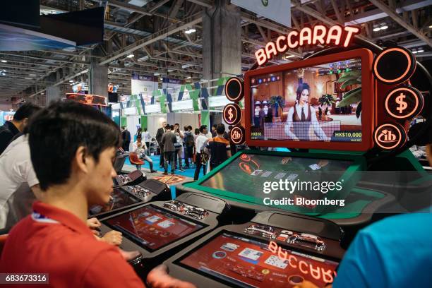 Attendees play baccarat at a gaming machine at the Global Gaming Expo inside the Venetian Macau resort and casino, operated by Sands China Ltd., a...