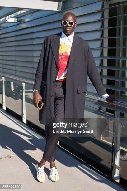 Contributor to L'Officiel Ukraine and New York Style Guide Badara Ndiaye wearing a Sandro coat, Prada shoes, Hugo Boss trousers and Peter and May...