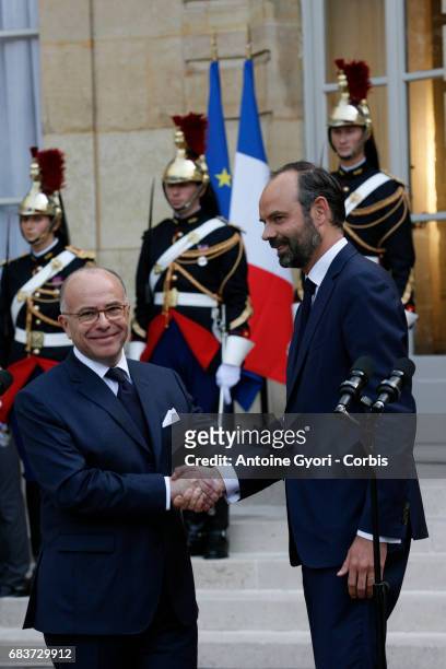France's newly-appointed Prime Minister Edouard Philippe and outgoing Prime Minister Bernard Cazeneuve shake hands during the official handover...