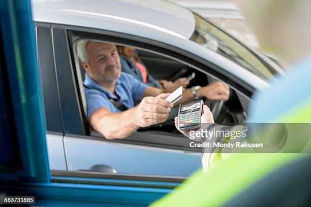 driver in car paying toll booth at bridge using contactless card payment technology - toll stock pictures, royalty-free photos & images