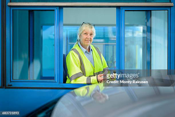 portrait of female toll collector at toll booth on bridge - toll stock pictures, royalty-free photos & images