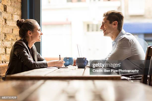 young businessman and woman meeting in cafe - little italy stock pictures, royalty-free photos & images