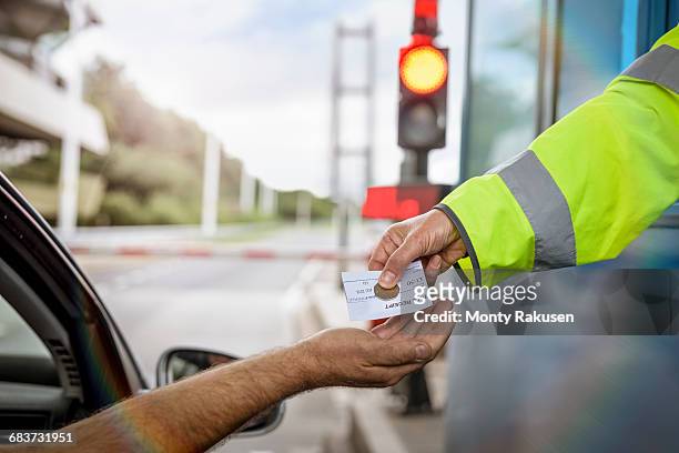 driver in car paying toll booth at bridge, close up - peaje fotografías e imágenes de stock