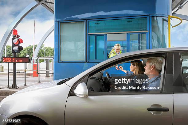 driver in car paying at toll booth at bridge - humber bridge stock-fotos und bilder