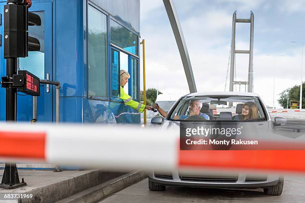 driver in car paying toll booth at bridge - humber bridge stock pictures, royalty-free photos & images