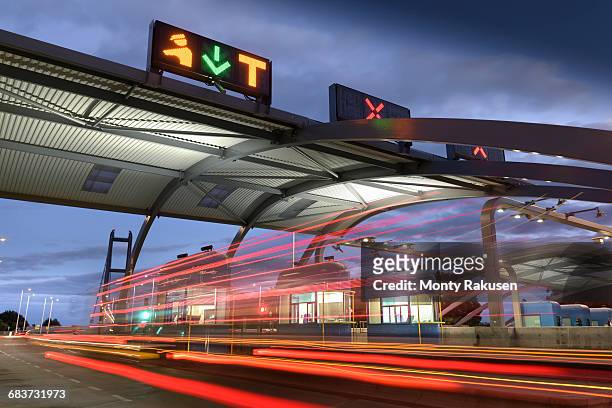 evening view of cars passing through toll booth at bridge - humber bridge stock pictures, royalty-free photos & images