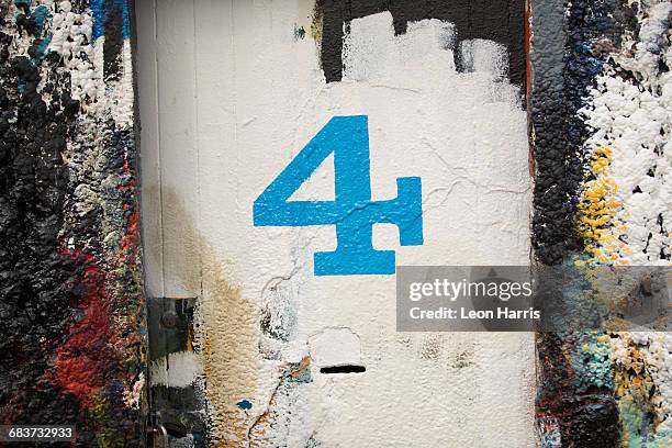 number 4 door and paint covered wall in ship painters yard - getal 4 stockfoto's en -beelden